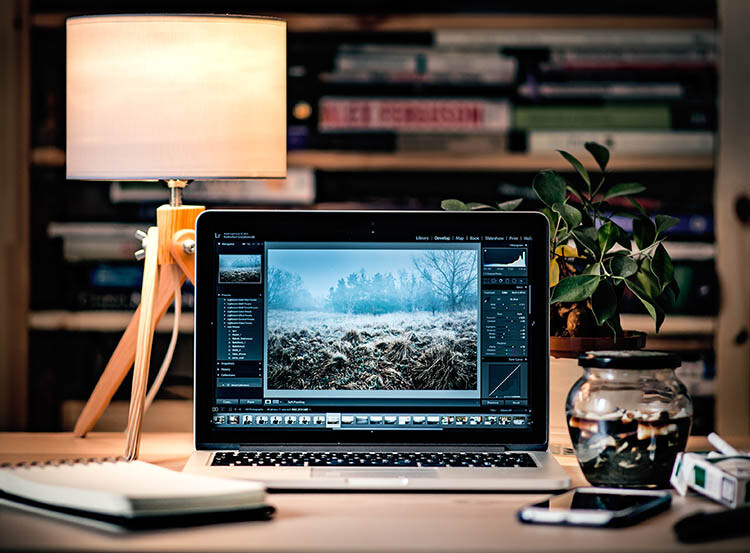 Laptop editing setup with winter landscape